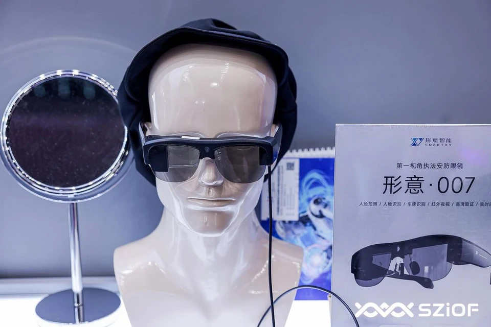 Physical Falcon 007 Pro reference glasses on a display mannequin, front view with the original exhibition sign and watermark