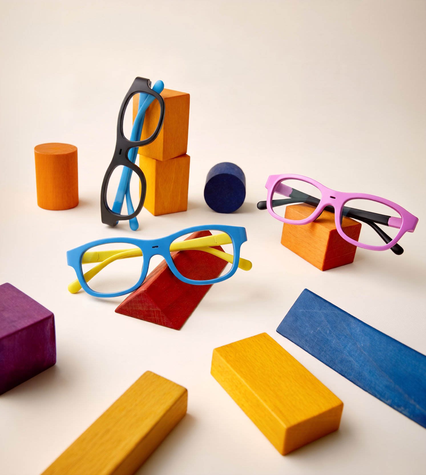 Three colorful Nudge eyewear colorways arranged with geometric blocks